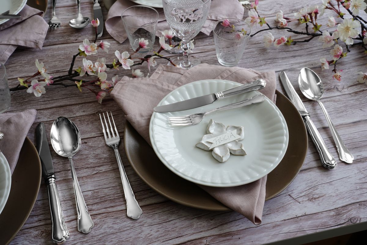 Dukning med silverbestick mot bakgrund av körsbärsblommor